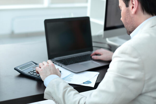 Businessman analyzing business expenses, focusing on evaluation of IT support outsourcing companies