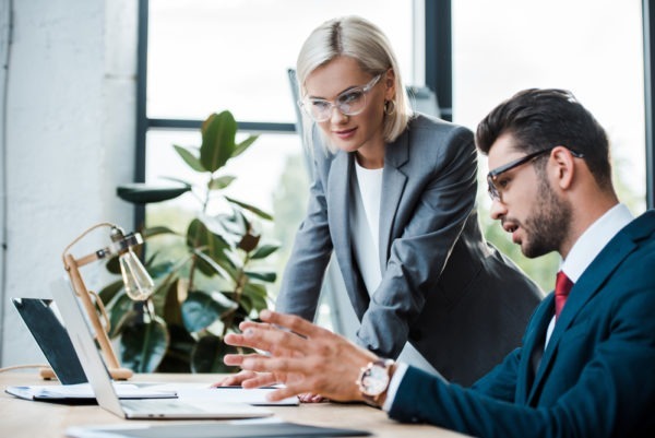 Two people working in front of a laptop - Business continuity plan and disaster recovery plans