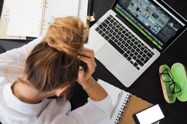 Female employee having difficulty working due to slow internet connection at the office.