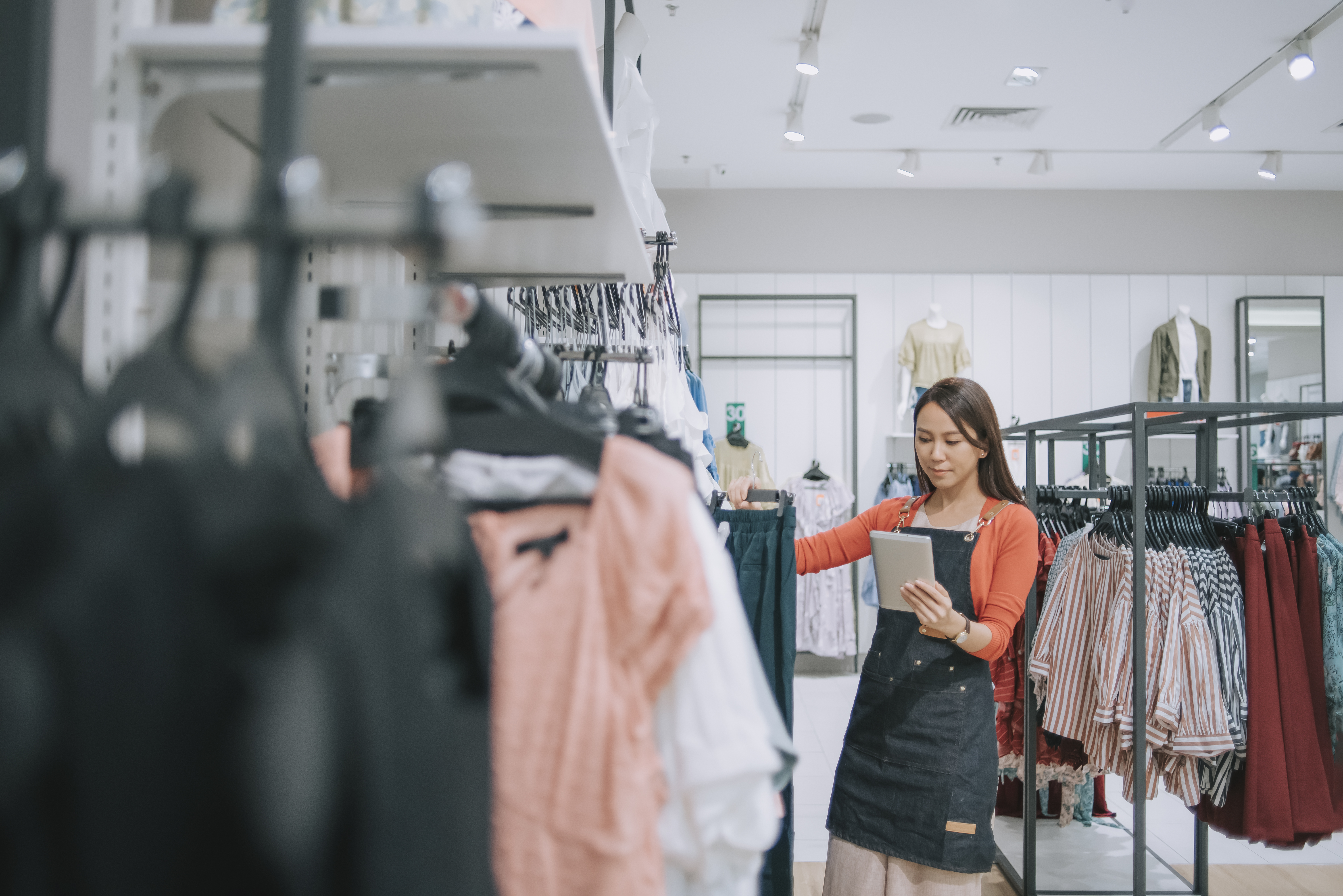 Asian chinese female boutique shop clothing store owner checking stock with digital tablet Office meeting concept image for IT Services for Retail