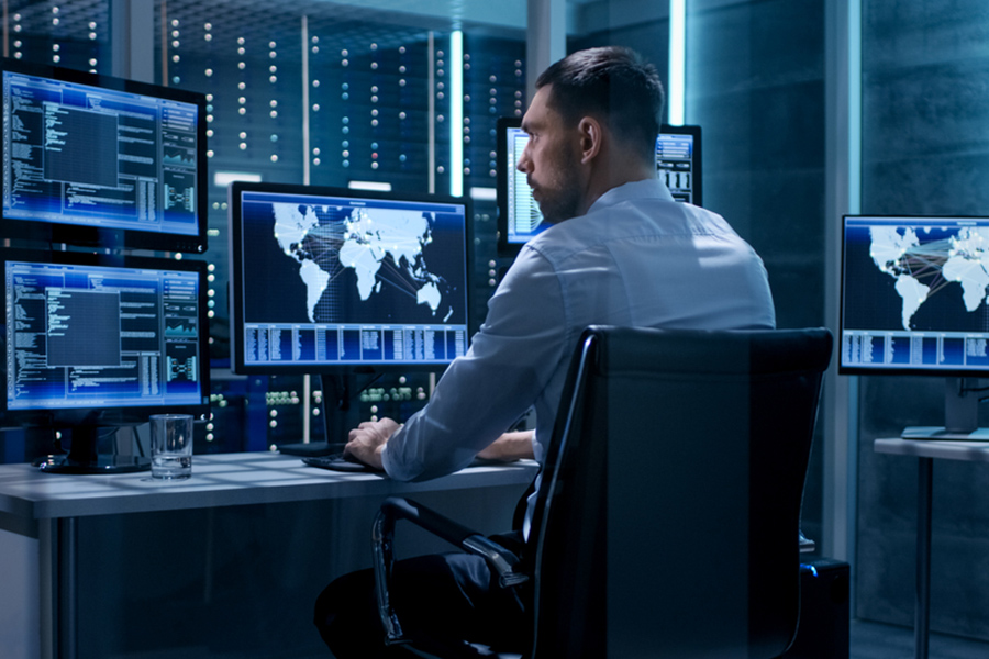 IT professional monitoring security in a network operations center in Singapore Business professional analyzing graphs on a computer, representing concierge IT services in Singapore for data-driven solutions