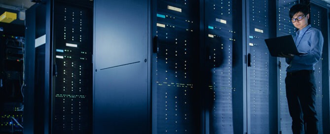 IT specialist performing an IT security assessment using a laptop inside the server room