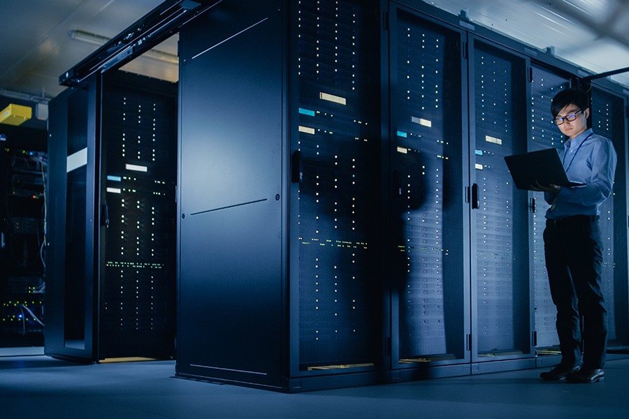 IT specialist performing an IT security assessment using a laptop inside the server room