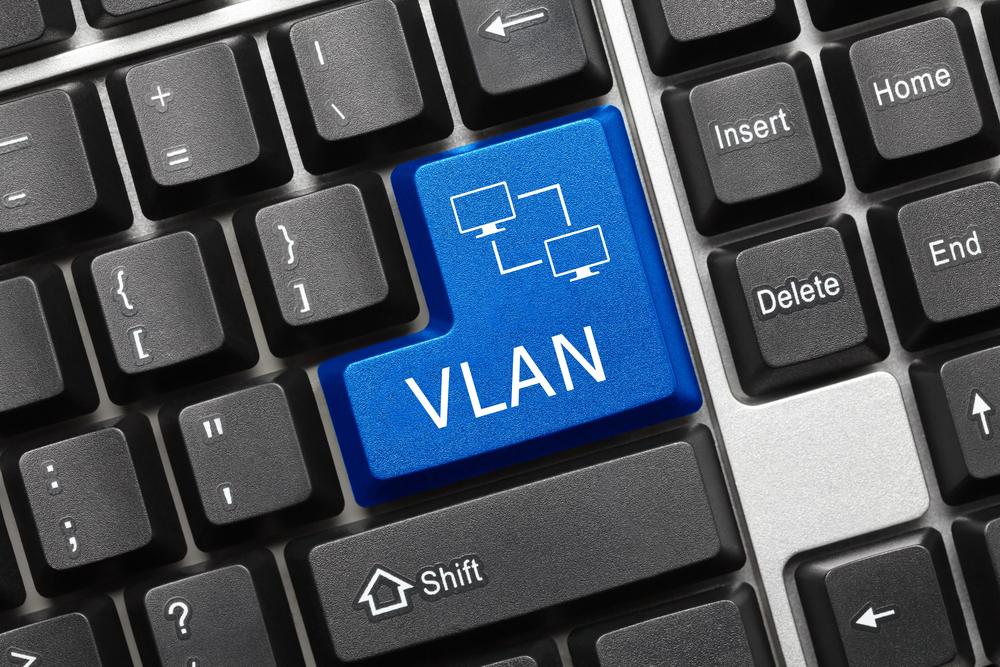 VLAN concept illustrated on a keyboard with a highlighted blue key labeled “VLAN” and a network diagram icon representing virtual network segmentation.