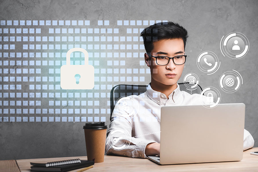 Young man working on laptop beside padlock icon concept for IT security Young man working on laptop beside padlock icon concept for IT security