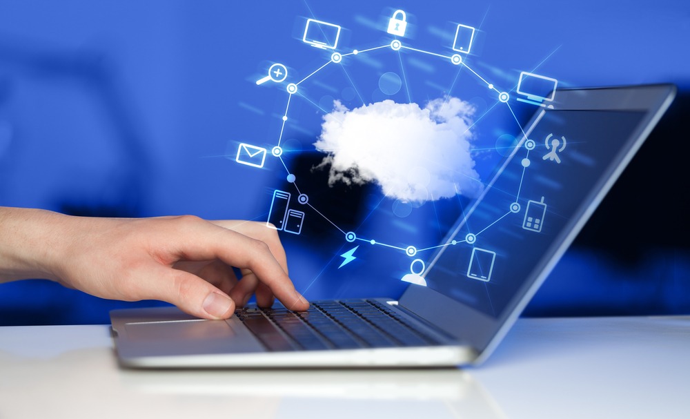  Hand on computer concept showing the business benefits of hybrid cloud. A hybrid cloud environment comprises a combination of private cloud services, public cloud services, and on-prem infrastructure.