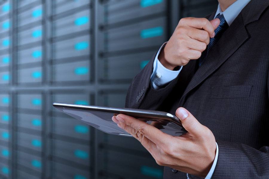 IT network professional wearing suit and tie holding tablet