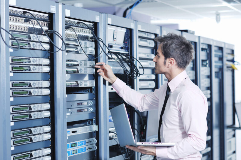 Network Penetration Testing Services in Hong Kong 2 A man in a white shirt is inspecting data servers and network security.